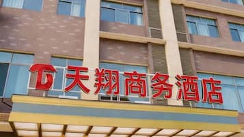 Un hotel con un letrero rojo llamativo que indica su nombre.