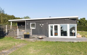 A modern house with a deck, a fire pit, and a large sliding glass door. - Stunning home in Roskilde (Roskilde)