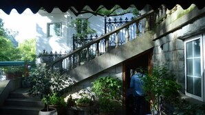 A staircase leading to a house with a stone facade, surrounded by potted plants. - Hangzhou Xuanzhe Homestay (Xihu Scenic Area Meijiawu) (Hangzhou)