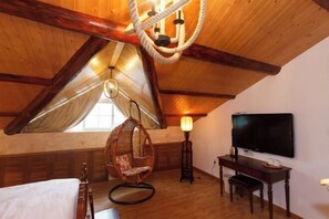 A cozy attic room with a sloped ceiling, a hanging chair, a desk, and a TV. - Hangzhou Xuanzhe Homestay (Xihu Scenic Area Meijiawu) (Hangzhou)