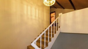 A staircase with white balusters and a wooden handrail, leading to a room with a chandelier. - Hangzhou Xuanzhe Homestay (Xihu Scenic Area Meijiawu) (Hangzhou)