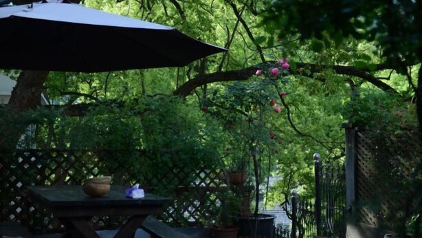 An outdoor patio area with a table, chairs, and a large umbrella. - Hangzhou Xuanzhe Homestay (Xihu Scenic Area Meijiawu) (Hangzhou)