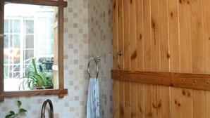 A bathroom with a wooden door, a mirror, and a sink with a towel hanging on the wall. - Hangzhou Xuanzhe Homestay (Xihu Scenic Area Meijiawu) (Hangzhou)