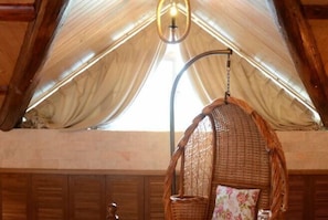 A rustic interior with a hanging chair, wooden paneling, and a large window with draped fabric. - Hangzhou Xuanzhe Homestay (Xihu Scenic Area Meijiawu) (Hangzhou)