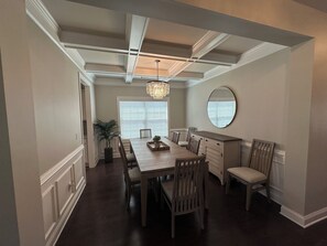 A dining room with a long wooden table, chairs, a chandelier, a potted plant, and a large mirror on the wall. - UGAvsVANDY, Perfect Gameday DAWG HOUSE!!! Sleeps 10+ Comfortably  (Athens)