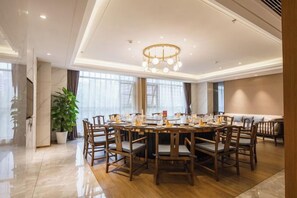 A spacious dining area with a round table and chairs, a chandelier, and large windows. - Wellton City Hotel (Ganzhou Railway Station) (Ganzhou)