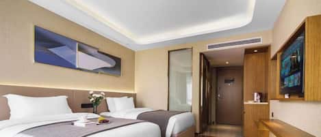 Une chambre d’hôtel avec deux lits, un téléviseur à écran plat, un bureau en bois et une grande fenêtre.