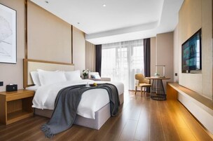 Una habitación de hotel moderna con cama, mesita de noche, silla y televisor.