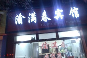 A hotel sign with Chinese characters and a contact number.