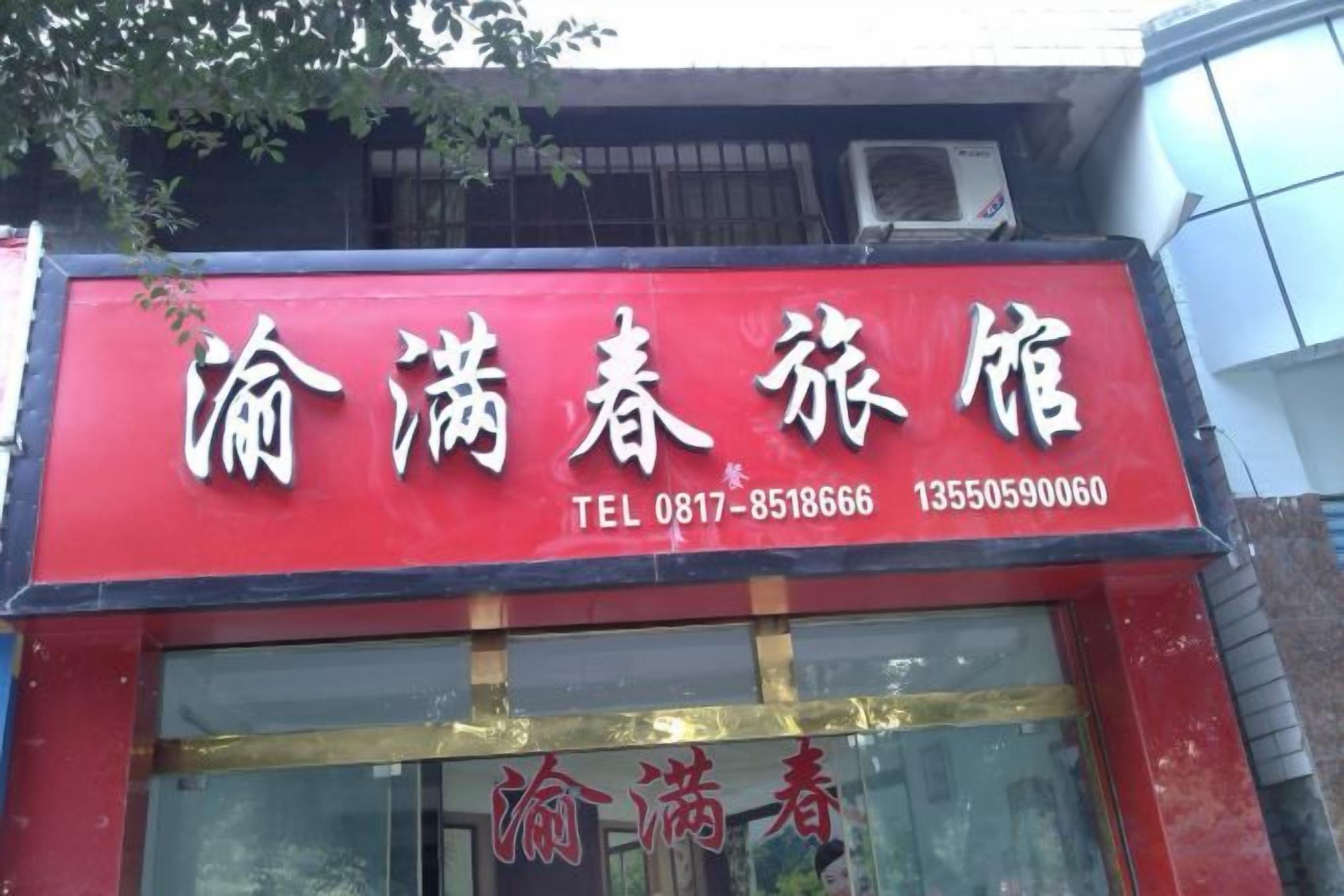 A red sign with white text for a hotel, including a telephone number and a website address.