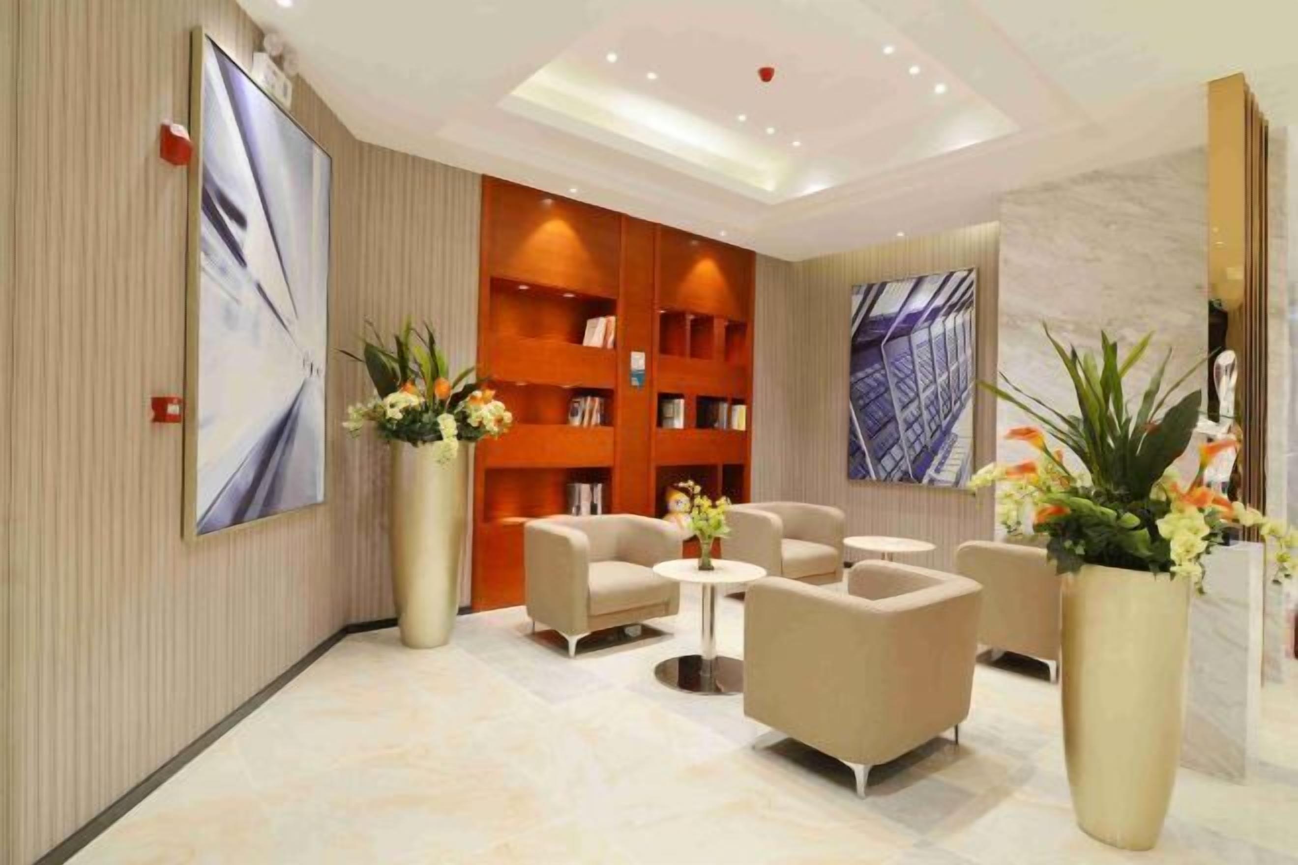 Una hall moderna con reception, area salotto e una grande libreria.