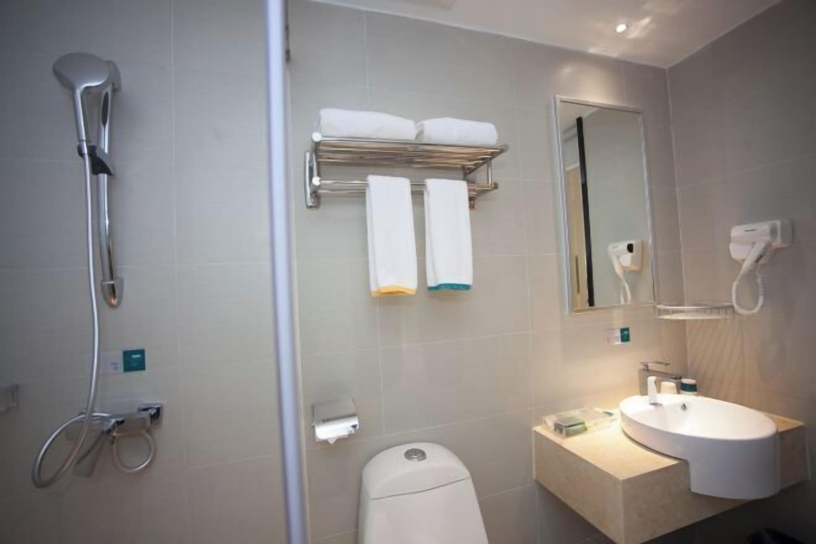 Une salle de bain moderne équipée d’une douche, de toilettes et d’un lavabo.