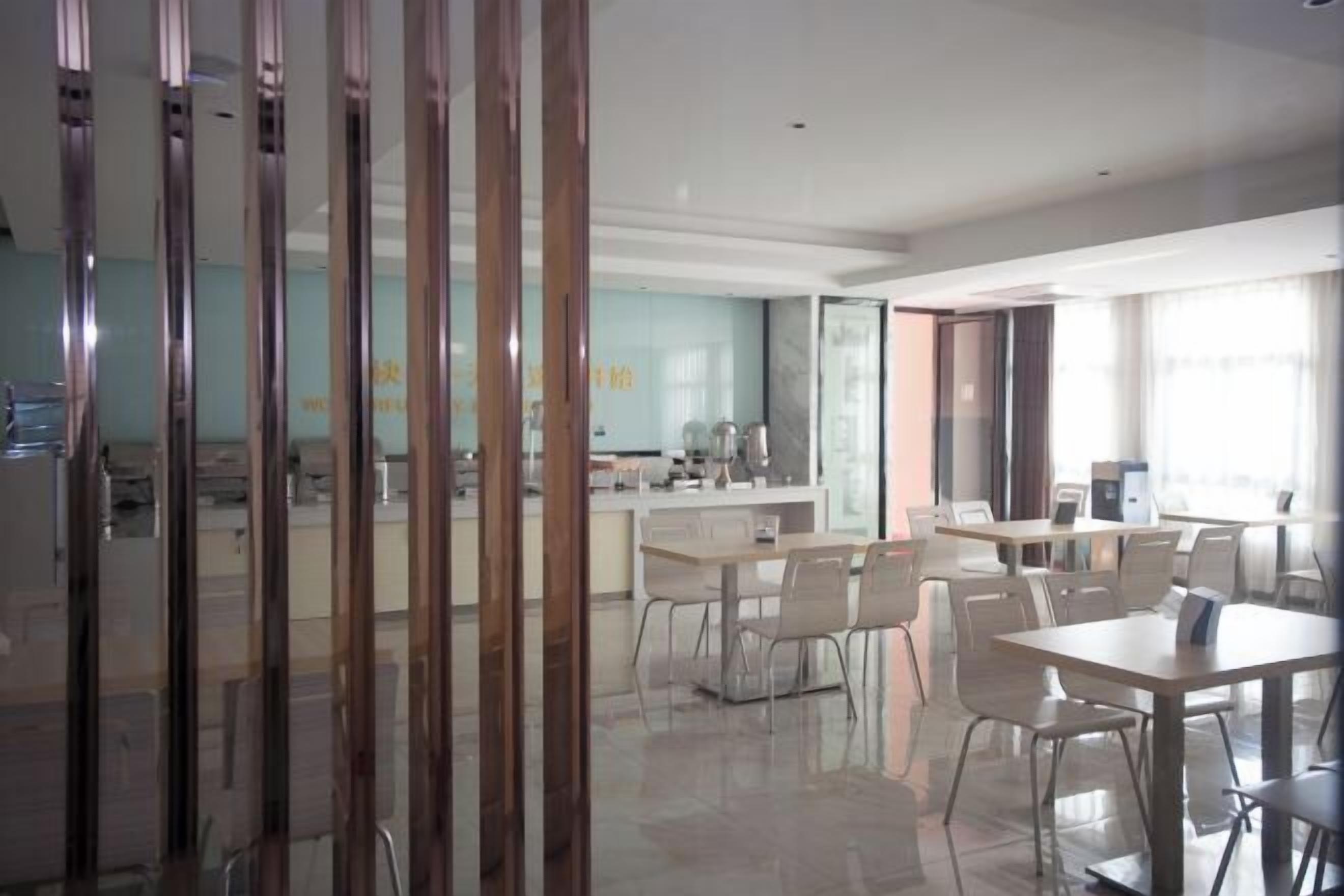 A modern dining area with a long counter, multiple tables, and chairs.