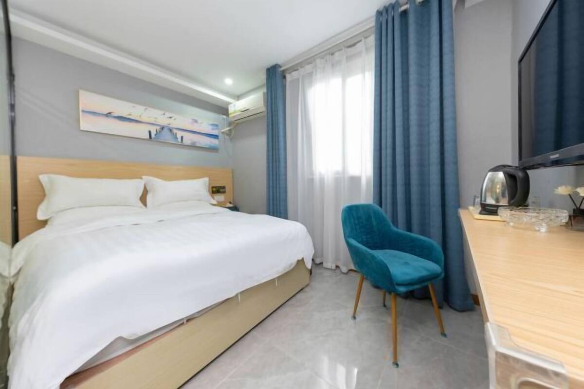 Een hotelkamer met een bed, bureau, stoel en televisie.