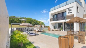 A modern villa with a swimming pool, outdoor seating, and a balcony. - Luxurious home in Vrvari with swimming pool (Vrvari)