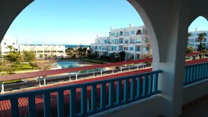 A view from a balcony with a pool and a building in the background. - Family spacious apartment with sea view, AC, WiFi, 7 mins walking to the beach (M'diq)