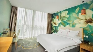 A hotel room with a bed, a desk, a chair, and a large window with curtains. - Shangri-La Business Hotel (Shouguang)