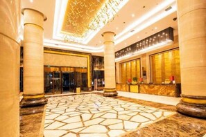 A spacious lobby with marble flooring, large columns, and a reception desk. - Huanuo Xinjinglun International Hotel (Changzhi)