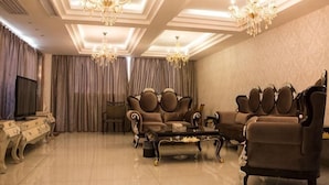 A spacious living room with a large sofa, a coffee table, and a television.