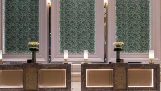 A reception area with a marble counter, two lamps, and a floral arrangement. - The Mulian Hotel (Hangzhou Future Science Town Alibaba Xixi Campus) (Hangzhou)