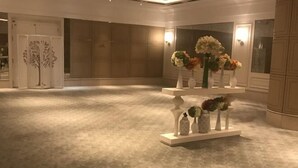 A spacious lobby with a central display of vases and flowers, a decorative tree, and a large mirror. - The Mulian Hotel (Hangzhou Future Science Town Alibaba Xixi Campus) (Hangzhou)