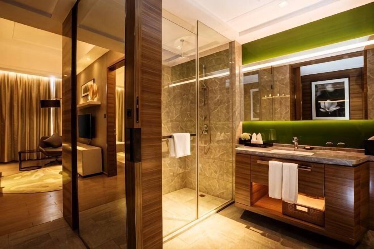 A modern bathroom with a glass shower enclosure, a vanity with a green countertop, and a separate shower area.