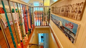 Una escalera con barandilla de madera y un muro con un mural histórico.
