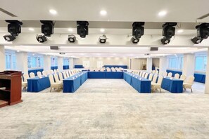 A conference room with a long table and rows of chairs, equipped with ceiling-mounted lighting. - Jinhua Hotel (Huangshi)
