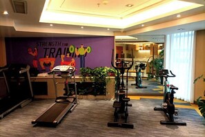 A gym with treadmills, stationary bikes, and a mirrored wall. - Jinhua Hotel (Huangshi)