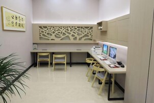 Una habitación con un escritorio, dos sillas, una computadora y una planta.