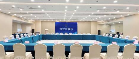 A conference room with a long table, chairs, and a banner.