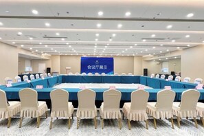 A conference room with a long table, chairs, and a banner.
