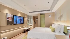 Una habitación de hotel moderna con cama, televisor, escritorio y baño.
