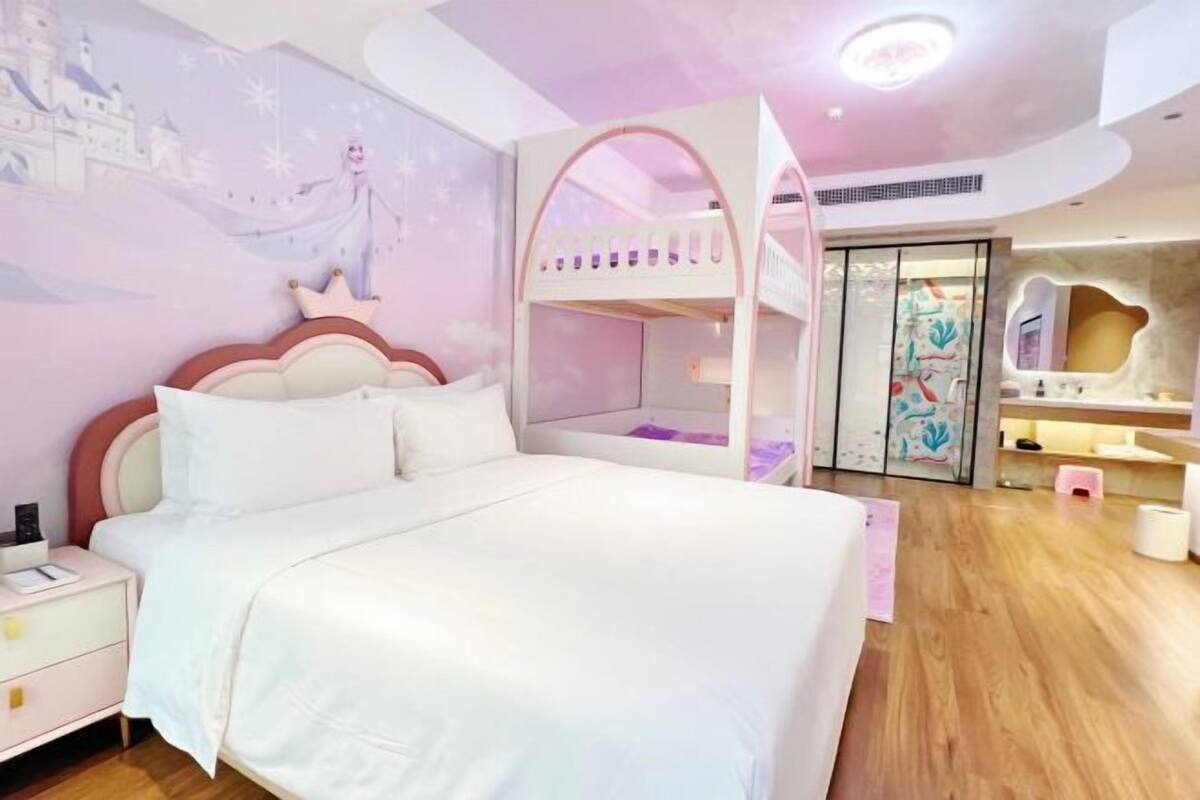Un dormitorio con literas, una mesita de noche y un mural en la pared.