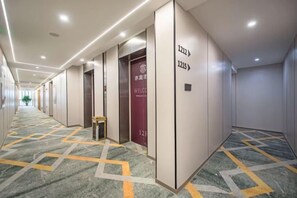 A hotel corridor with directional signs, a reception desk, and a patterned carpet. - Yiting Hotel (Chongqing)