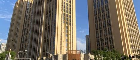 Un edificio alto con un diseño arquitectónico moderno, que presenta una grilla de ventanas y un techo plano.