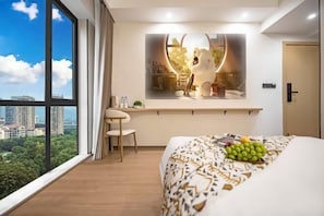 A modern hotel room with a large bed, a desk, and a view of the city. - Yiting Hotel (Chongqing)