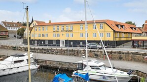 En gul bygning med skiltet "HOTEL ØSTERSØEN", der angiver et hotel.
