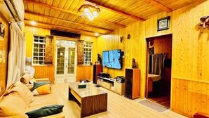 Un interno in legno con un divano, un tavolino da caffè, una televisione e un camino.