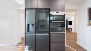 Una cocina moderna con refrigerador, horno y dispensador de agua incorporados.