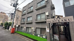 Un edificio de varios pisos con un letrero que dice "OUMEKAKU".