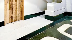 Una escalera con una puerta de madera y paredes blancas.