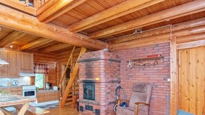 Interior acogedor de una cabaña con cocina, chimenea, comedor y zona de estar.