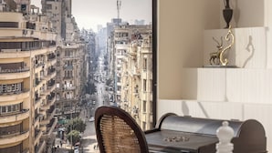 Ein Zimmer mit Blick auf eine Stadtstraße, inklusive Schreibtisch, Stuhl und Bett.