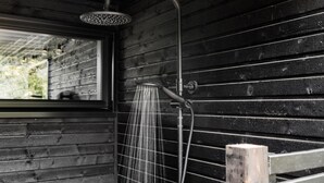 A shower with a rain shower head, a window, and wooden walls. - Cozy home in Hornbæk with WiFi (Hornbæk)
