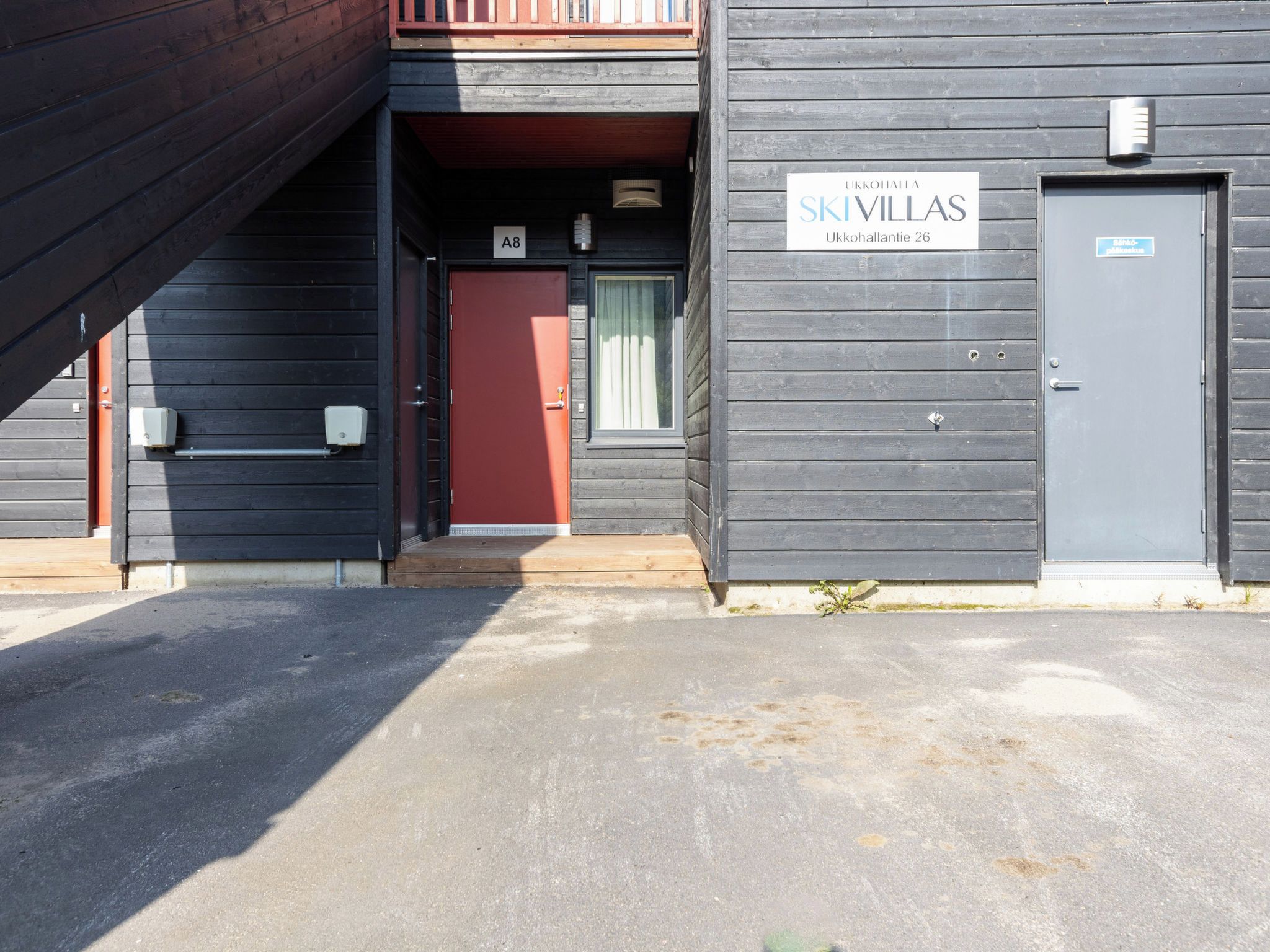 A building with a red door and a sign that reads 'SKIVILLAS Ukkohallantie 26'.