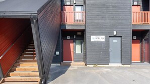 En moderne bygning med flere balkoner, en trappe og et skilt med teksten 'SKIVILLAS'.