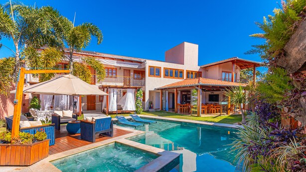 A hotel with a swimming pool, outdoor seating, and a well-maintained garden. - Pousada Vila Rica (Pirenópolis)