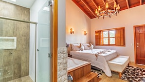 A bedroom with a bed, a window, a chandelier, and a wooden ceiling. - Pousada Vila Rica (Pirenópolis)