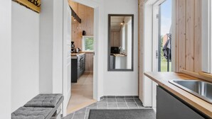 A modern kitchen with wooden accents, a built-in oven, and a large window.